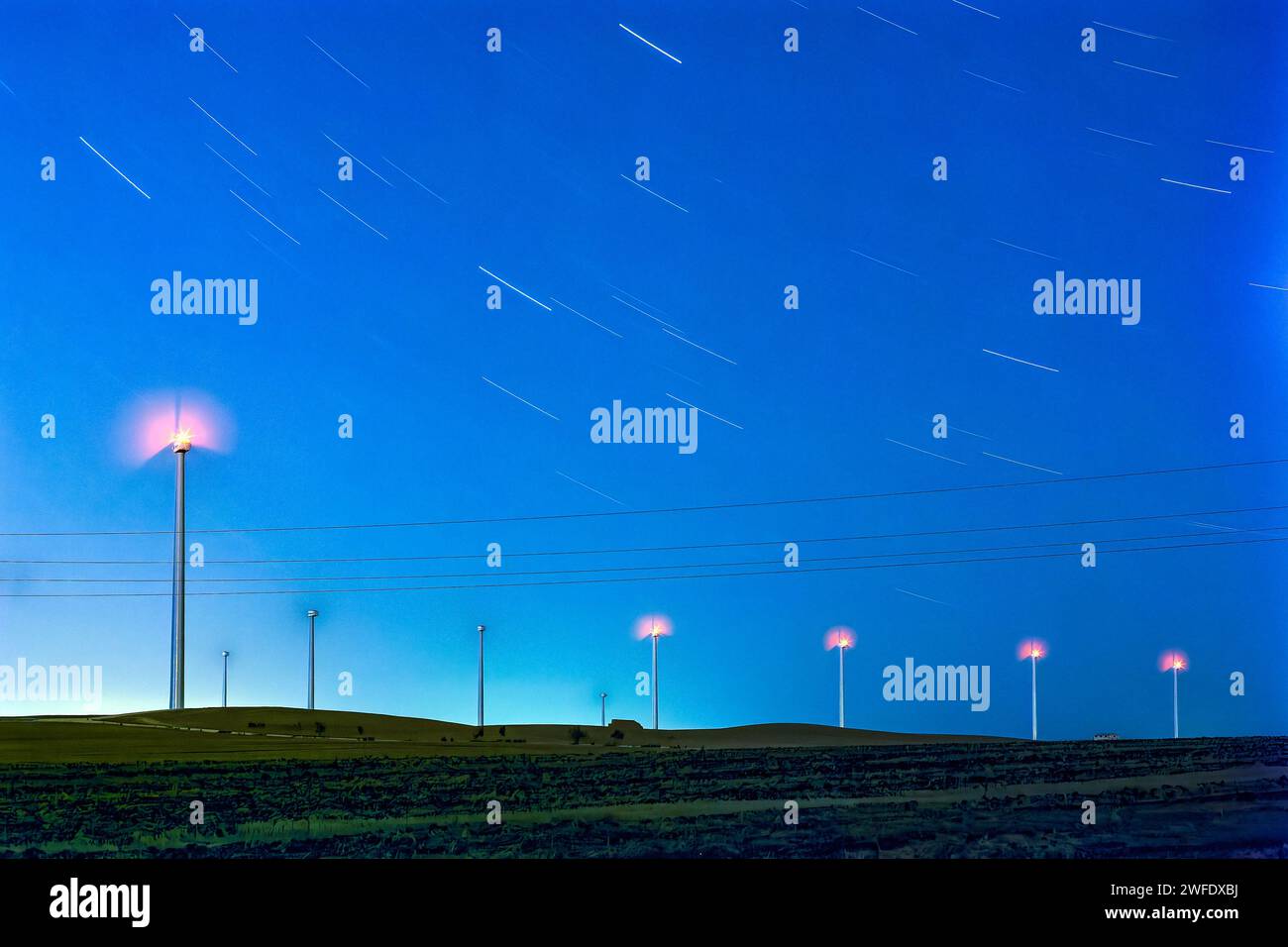 Nuit étoilée au-dessus des moulins à vent espagnols - Une longue exposition fascinante capturant la beauté sereine des éoliennes sur fond de sentiers d'étoiles Banque D'Images