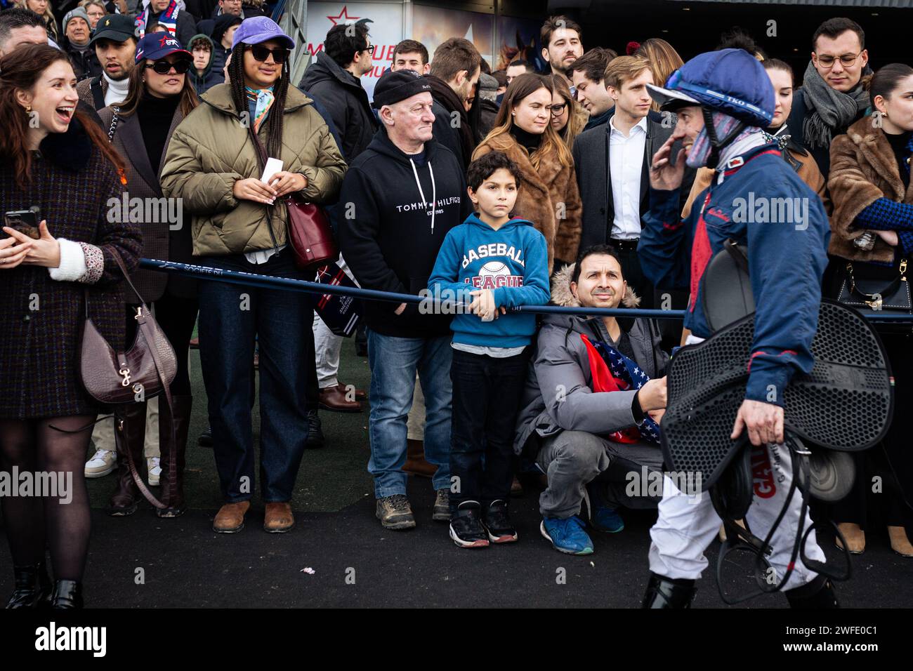 Les gens regardent le jockey Guillaume Martin, après sa course, à l'hippodrome de Vincennes. La course de trot la plus connue au monde, le Prix d'Amerique Legend Race, s'est déroulée sur l'hippodrome de Vincennes, en périphérie de Paris. Cette course reste l'une des plus importantes courses équestres au monde, elle est suivie par des millions de spectateurs. Clément Duvaldestin et son cheval IDAO de Tillard, ont été les gagnants du Grand Prix d'Amerique 2024. Banque D'Images