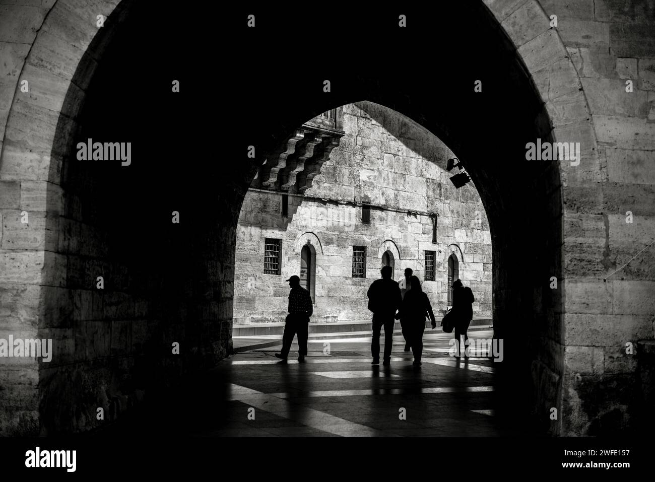 Silhouette d'un peuple marchant vers la lumière d'un tunnel. Banque D'Images