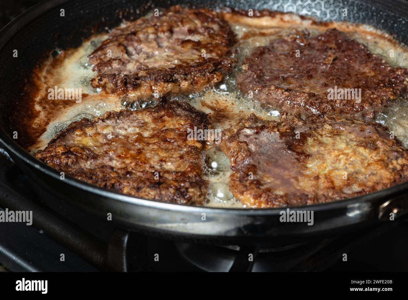 Schnitzel frit dans une poêle sur la table de cuisson à gaz. Concept de cuisine maison. Banque D'Images