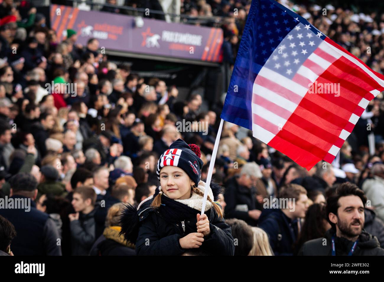 Vincennes, France. 28 janvier 2024. Un enfant vu avec les deux drapeaux de France et des Etats-Unis d'Amérique, lors du Grand Prix d'Amerique. La course de trot la plus connue au monde, le Prix d'Amerique Legend Race, s'est déroulée sur l'hippodrome de Vincennes, en périphérie de Paris. Cette course reste l'une des plus importantes courses équestres au monde, elle est suivie par des millions de spectateurs. Clément Duvaldestin et son cheval IDAO de Tillard, ont été les gagnants du Grand Prix d'Amerique 2024. (Photo Telmo Pinto/SOPA Images/Sipa USA) crédit : SIPA USA/Alamy Live News Banque D'Images