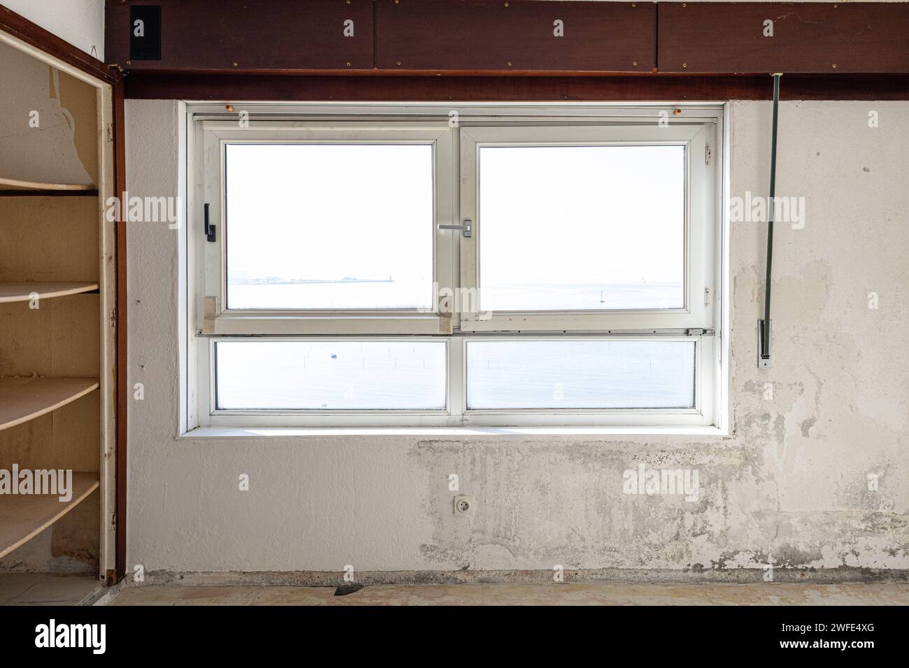 Vue intérieure d'une fenêtre endommagée dans une pièce âgée prête à être rénovée. Concept d'amélioration de la maison Banque D'Images