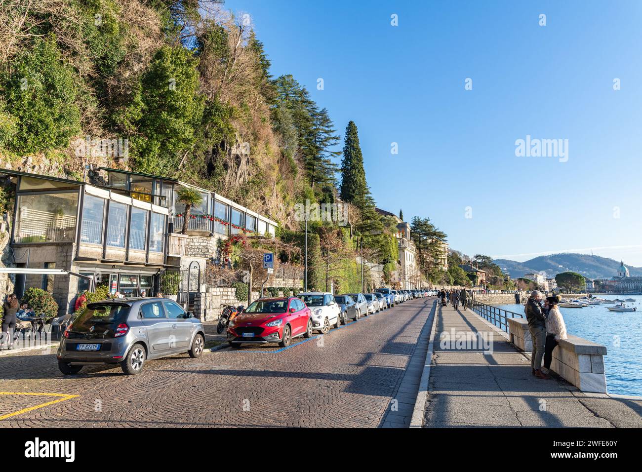 Personnes / touristes marchant le long d'une promenade par le lac de Côme à Côme, Italie Banque D'Images