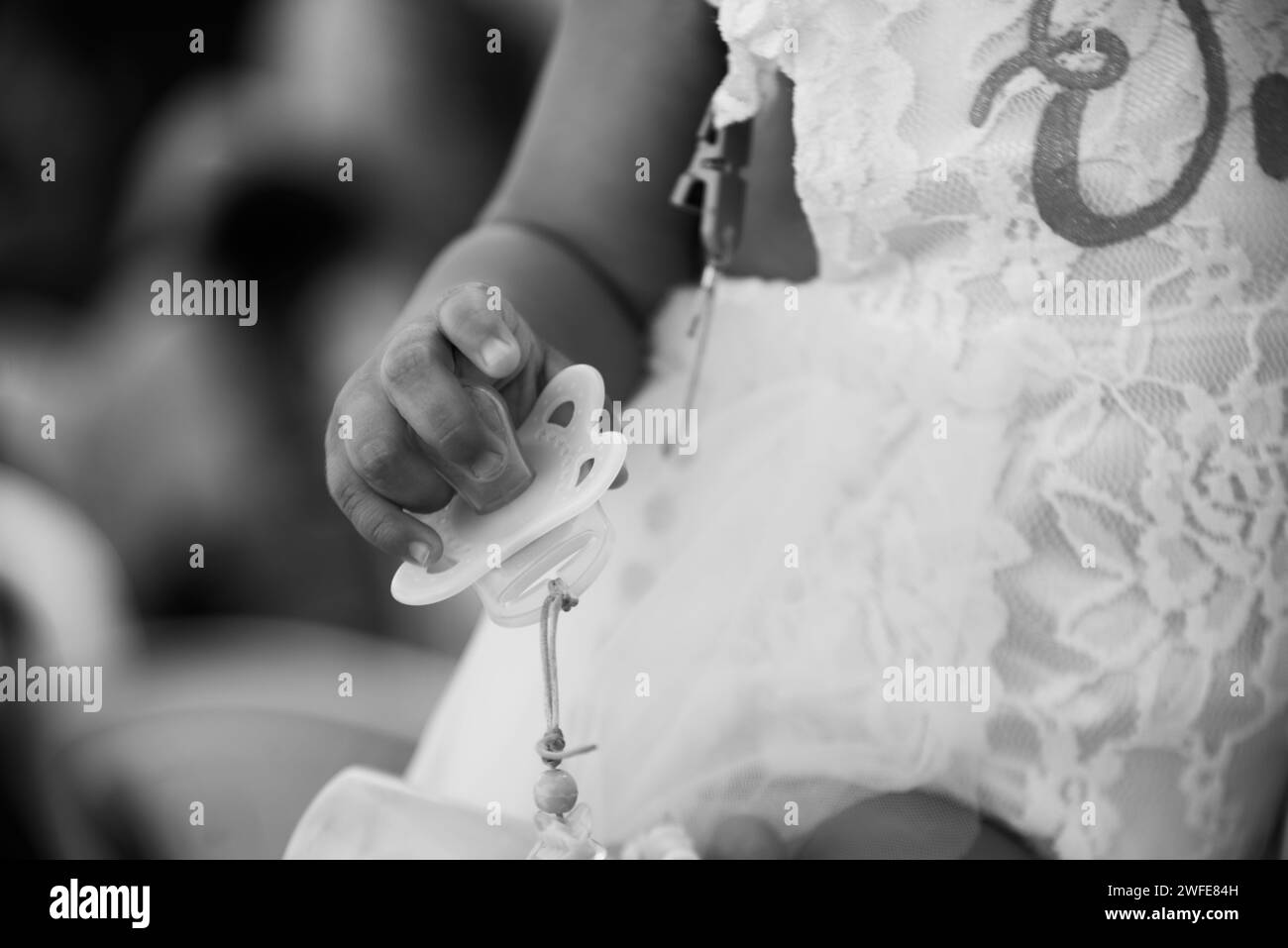 Une photo en noir et blanc d'un enfant tenant une sucette Banque D'Images