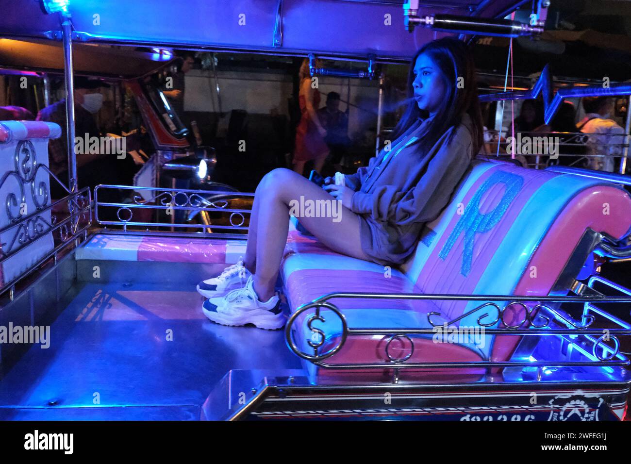 Une fille vape dans un tuktuk, Sukhumvit soi 4, Bangkok, Thaïlande Banque D'Images