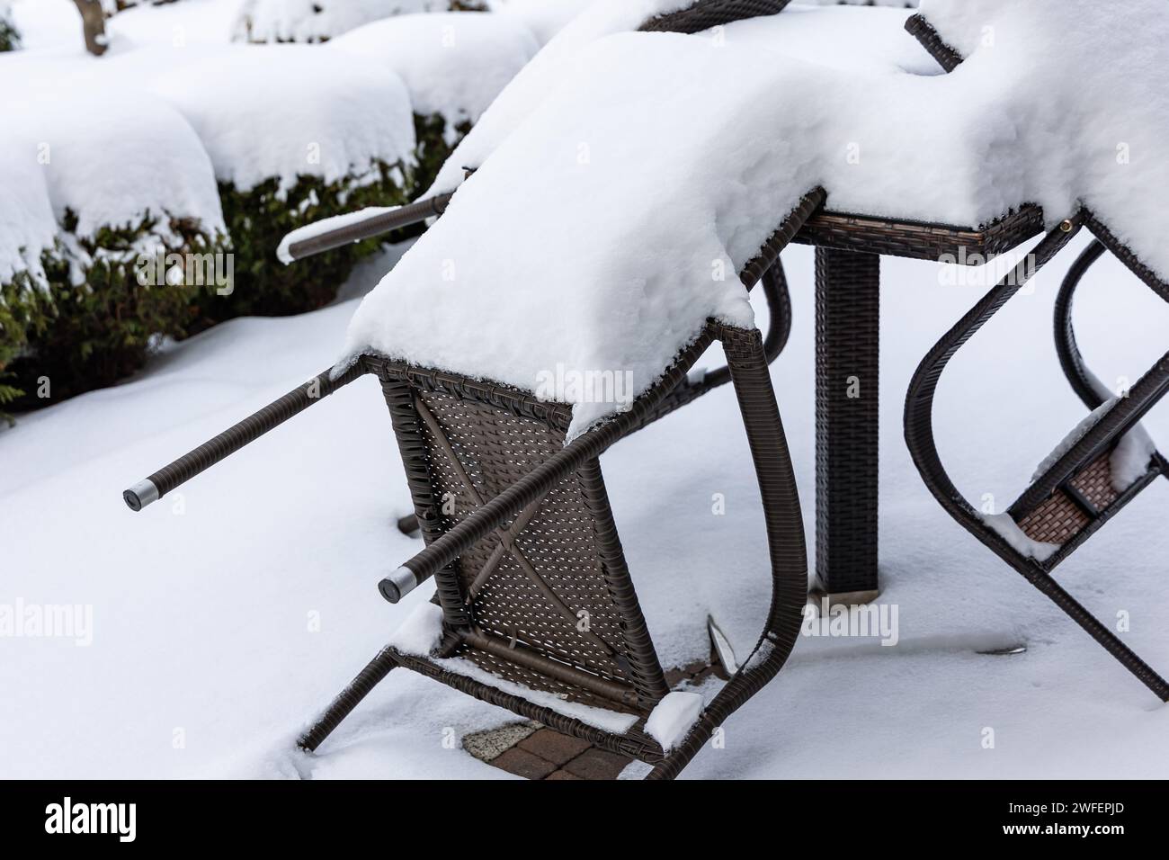 Chaises en plastique et une table de jardin recouverte d'une épaisse couche de neige. Meubles de jardin non protégés pour l'hiver. Banque D'Images