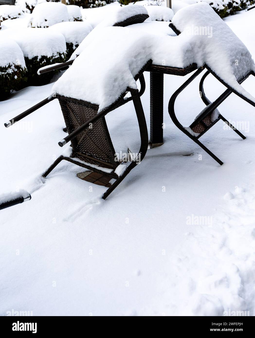 Chaises en plastique et une table de jardin recouverte d'une épaisse couche de neige. Meubles de jardin non protégés pour l'hiver. Banque D'Images