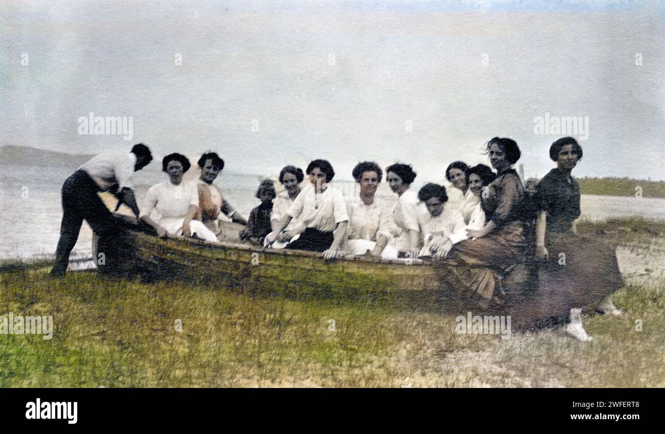 11 femme, 1 enfant et 1 homme dans une barque sur l'herbe, vers 1911. Banque D'Images