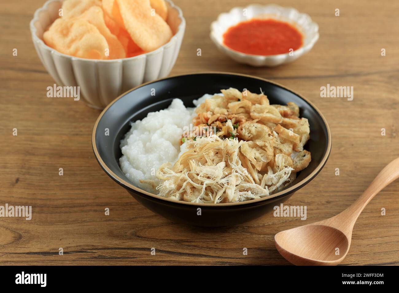 Bubur Ayam ou bouillie de riz indonésien avec poulet râpé. Servi avec Kerukpuk (Cracker), sauce soja, haricots de soja frits et sambal Banque D'Images