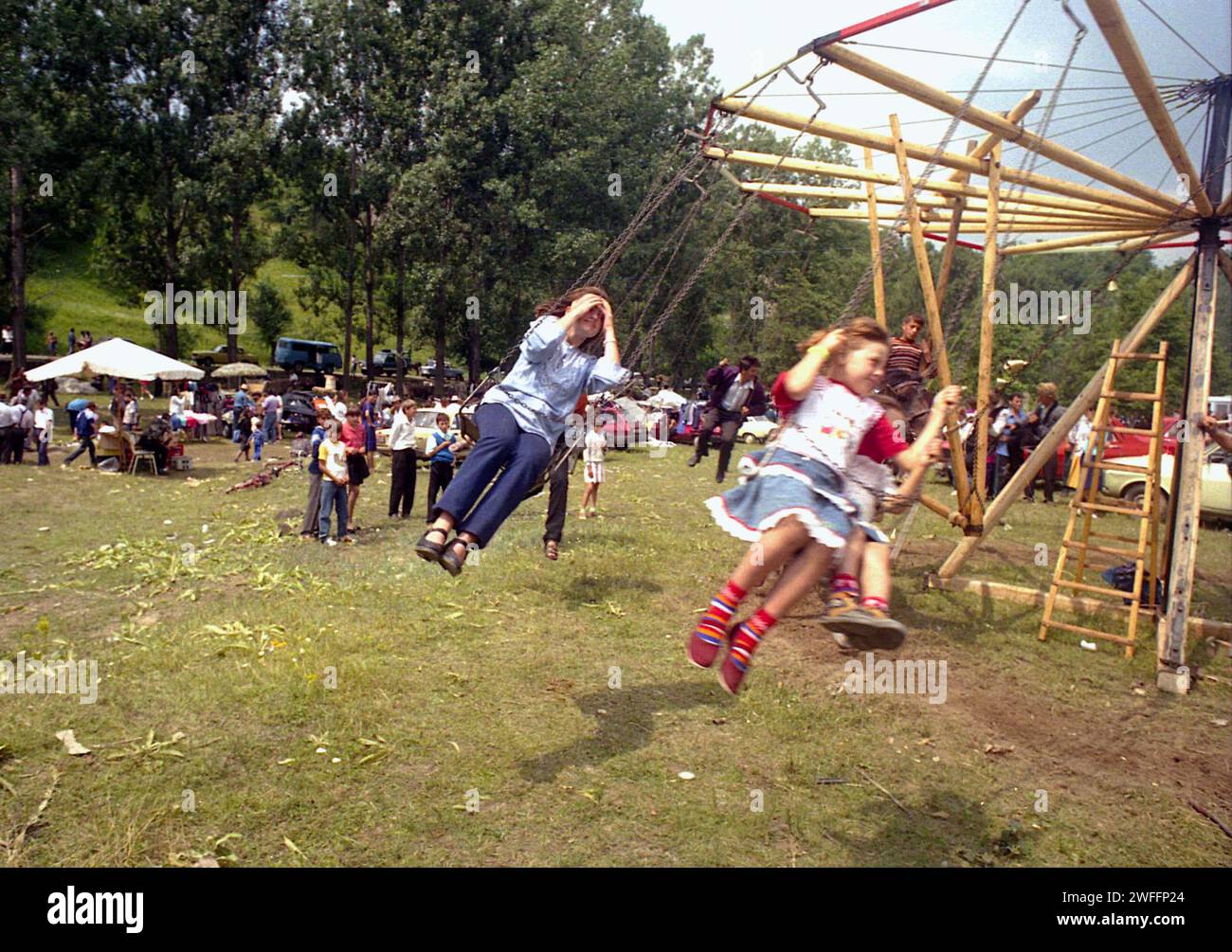 Comté de Vrancea, Roumanie, env. 1992. Les gens locaux profitant d'un tour à la foire de campagne dans la chaîne des balançoires tournées par un cheval. Banque D'Images