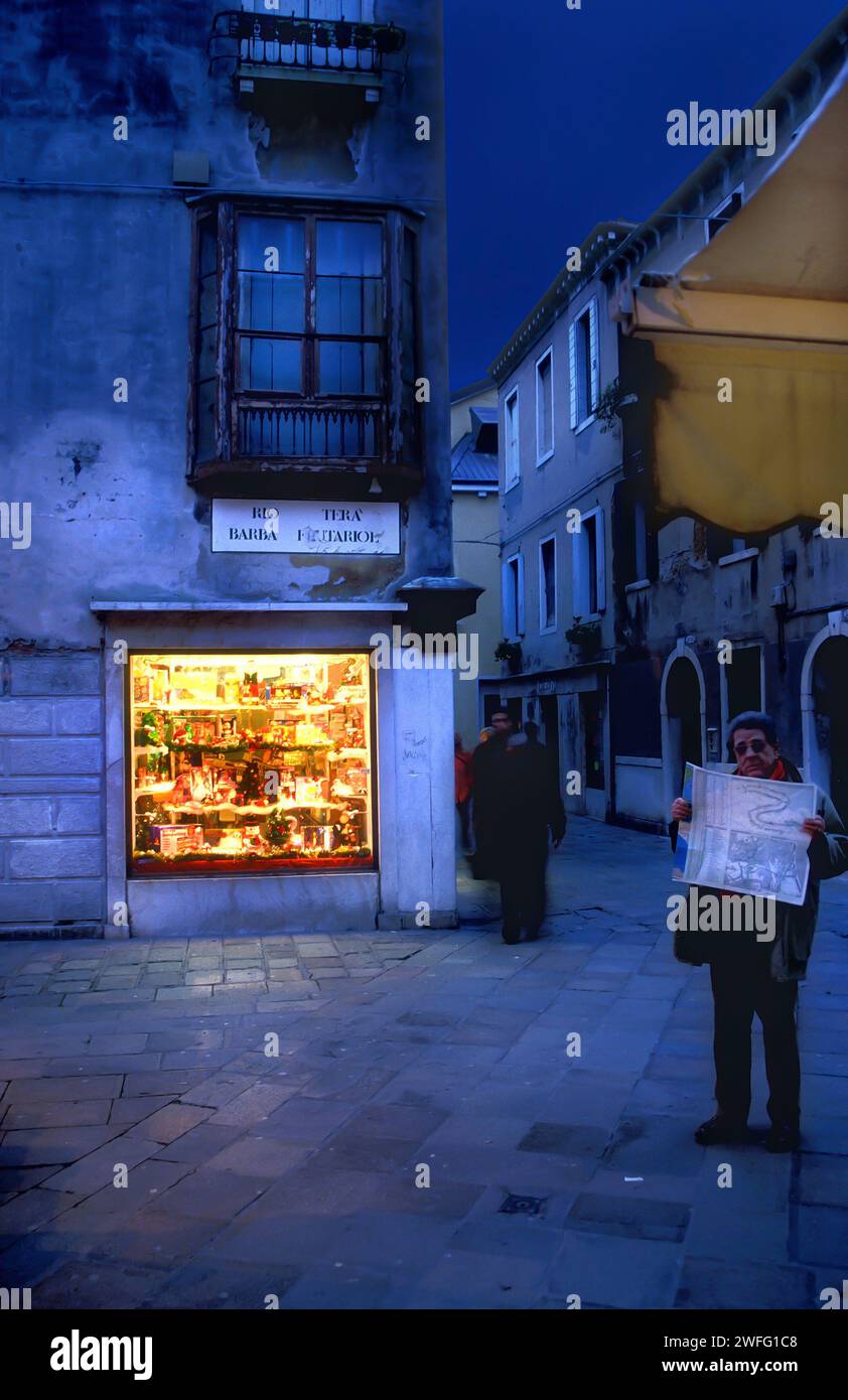 Homme lisant une carte touristique dans la lumière bleue de l'heure du soir, Venise, Italie Banque D'Images