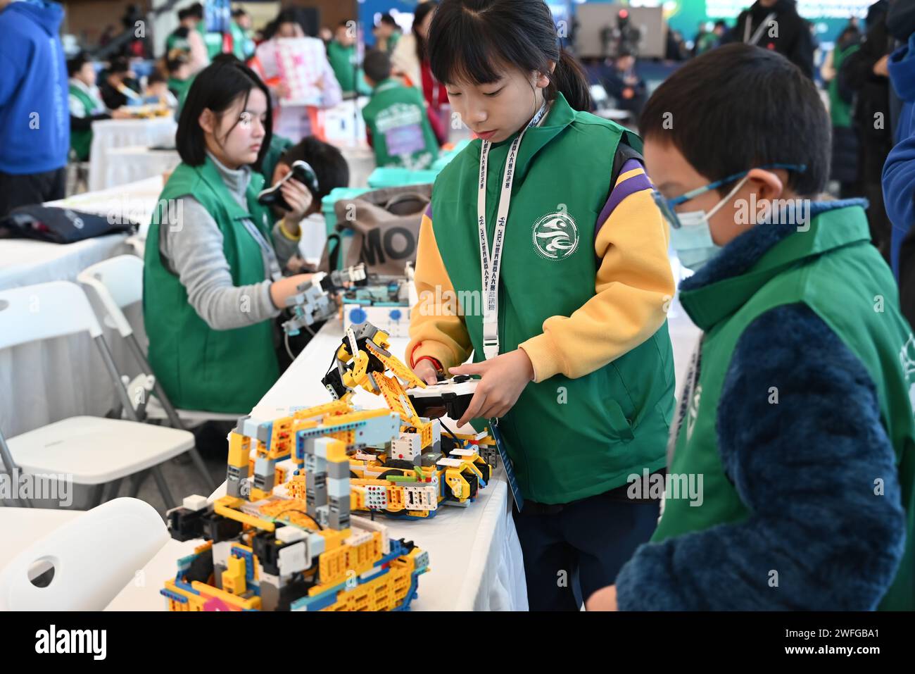 Fusong, province chinoise de Jilin. 26 janvier 2024. Les jeunes participants déboguent leurs robots lors de la finale du concours mondial de robots 2023 dans le comté de Fusong, Baishan City, province de Jilin dans le nord-est de la Chine, le 26 janvier 2024. POUR ALLER AVEC 'China Focus : l'éducation robotique gagne en popularité parmi les jeunes Chinois crédit : Song Xinping/Xinhua/Alamy Live News Banque D'Images