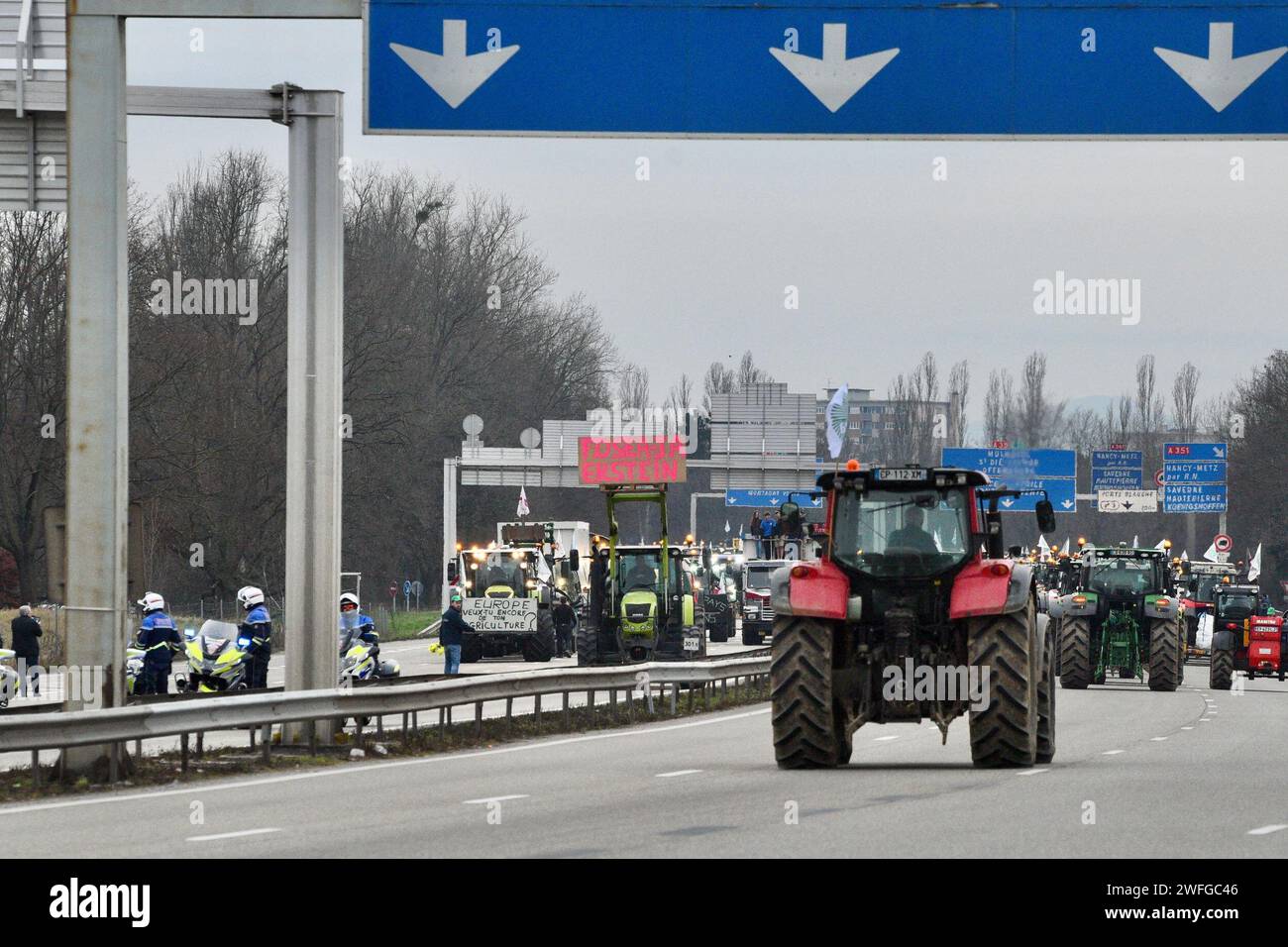 L'autoroute A35 est bloquée par des tracteurs agricoles depuis 4h le mardi 30 janvier 2024, à Strasbourg, dans le nord-est de la France. La police française a averti qu'environ 1 000 agriculteurs et 500 tracteurs barricadaient les routes à travers la France, et que les manifestations pourraient s'intensifier cette semaine en raison des demandes des agriculteurs pour de meilleurs prix pour leurs produits et plus de soutien du gouvernement. Le nouveau Premier ministre, Gabriel Attal, a déclaré mardi au Parlement que l’agriculture française est « notre force et notre fierté ». Il a promis que la France travaillerait à étendre une exemption sur les règles européennes en jachère et que Paris mettrait en place un fonds d’urgence pour lutter contre la victoire Banque D'Images