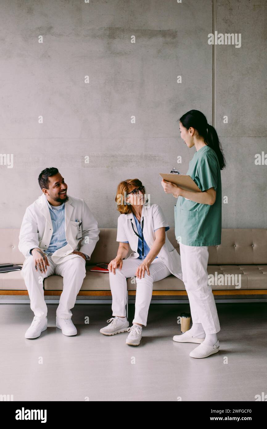 Heureux collègues médicaux multiraciaux discutant à l'hôpital Banque D'Images