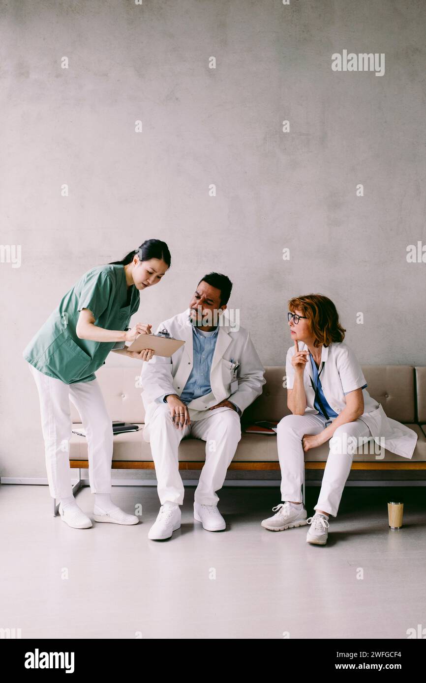 Collègues médicaux multiraciaux discutant à l'hôpital Banque D'Images