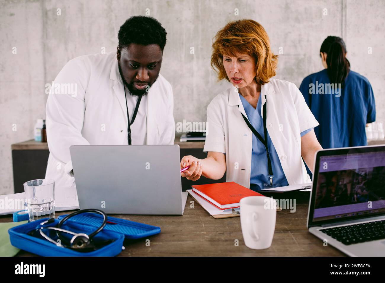Collègues médicaux discutant sur ordinateur portable au bureau à l'hôpital Banque D'Images