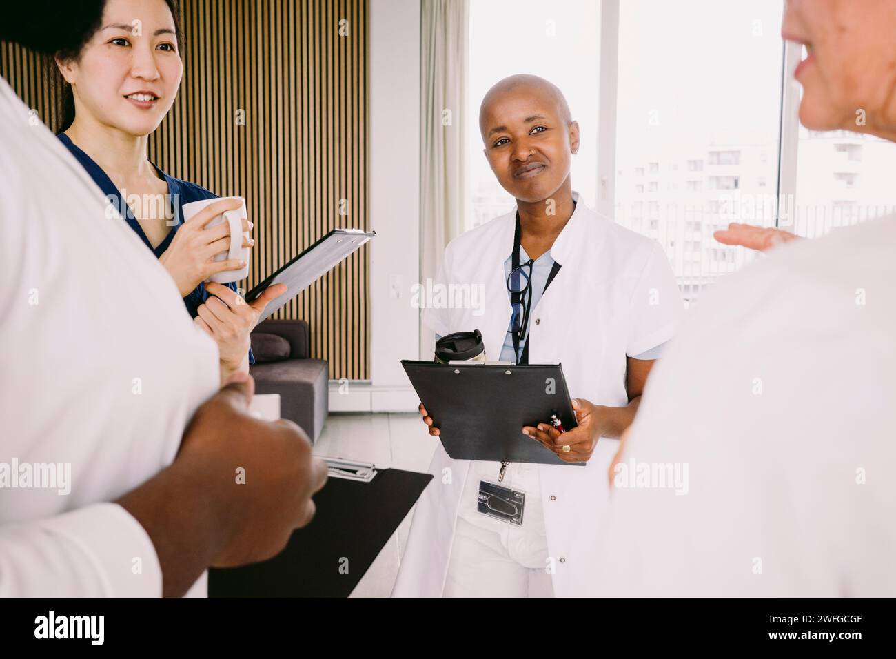Équipe de soins multiraciaux discutant en position d'hôpital Banque D'Images