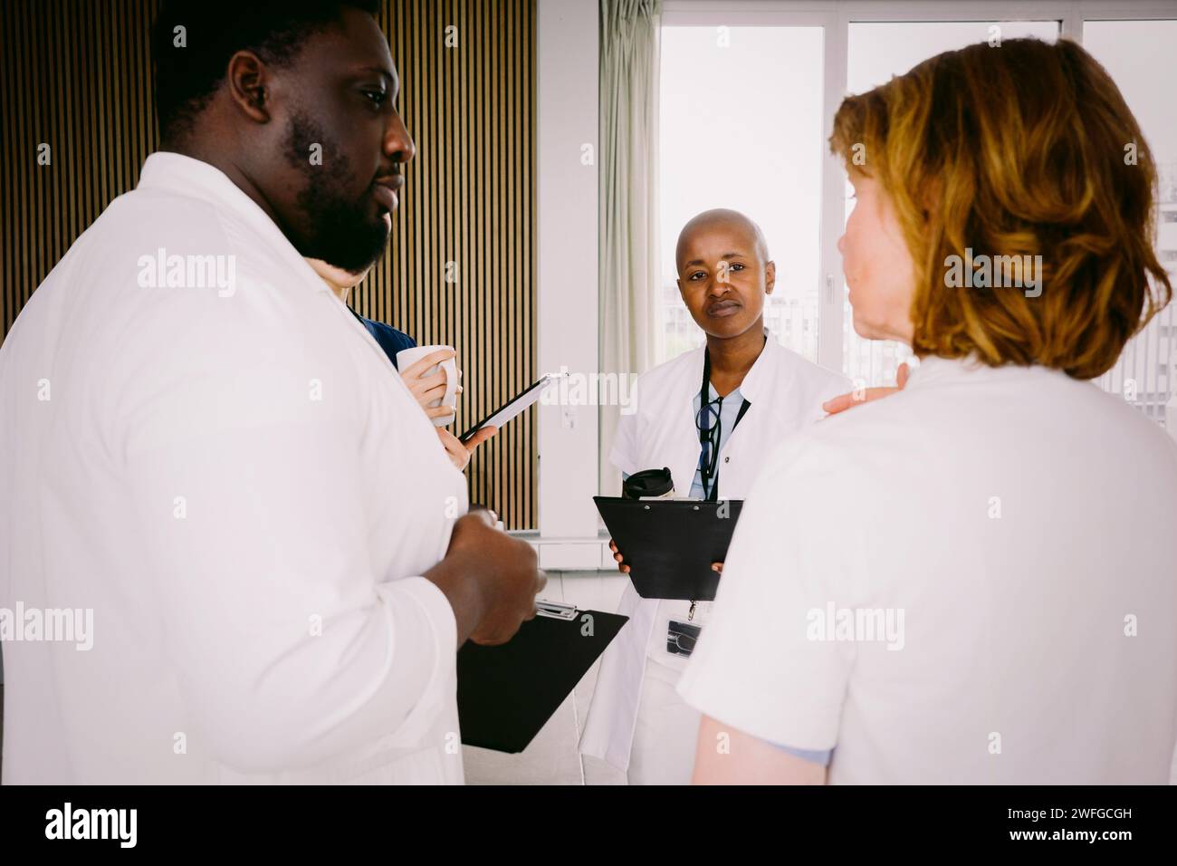 Equipe de médico-sociaux discutant debout à l'hôpital Banque D'Images