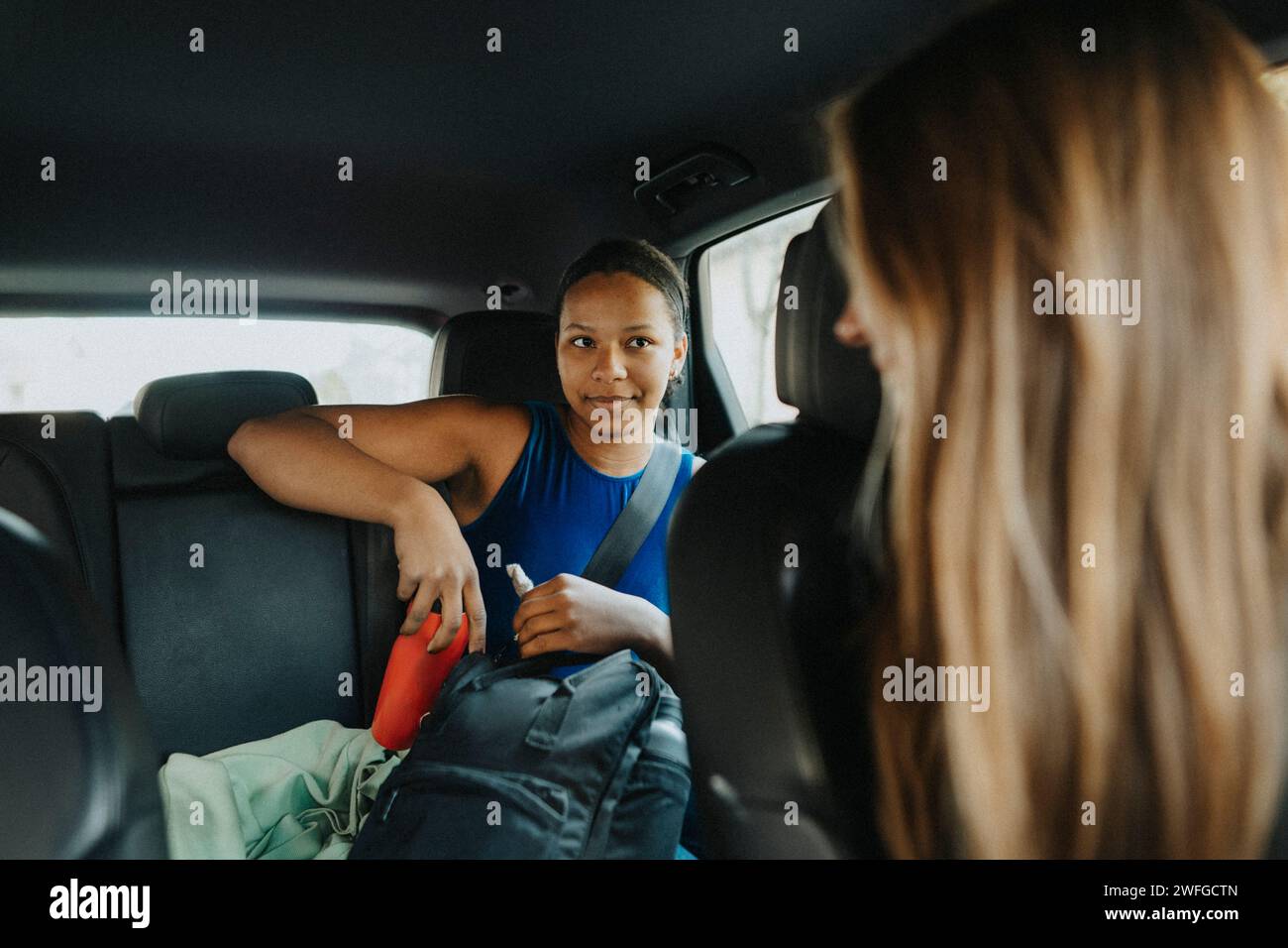 Coach blonde parlant avec une adolescente assise dans la voiture Banque D'Images