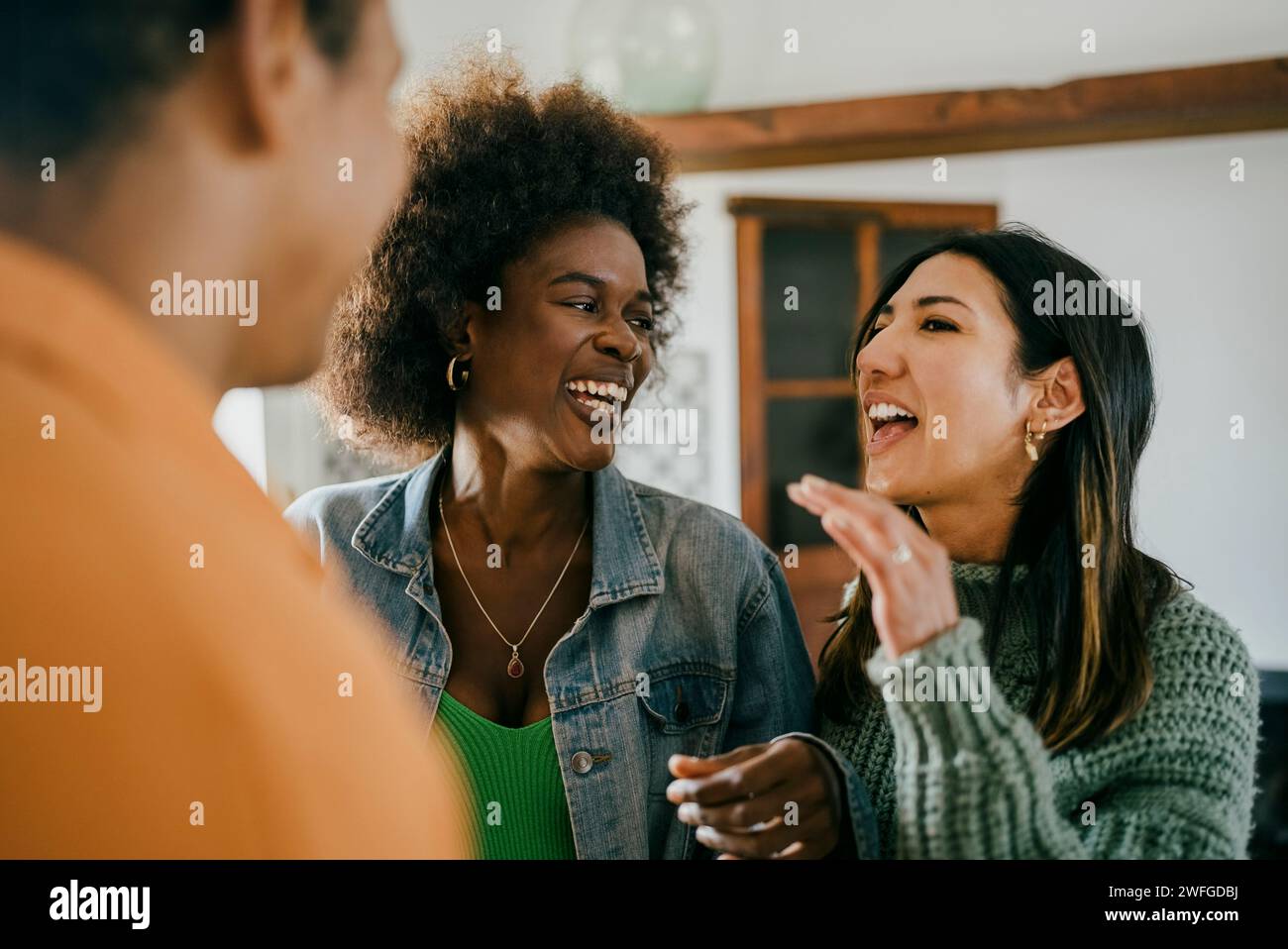 Femme heureuse parlant avec des amis à la fête dans la cuisine Banque D'Images