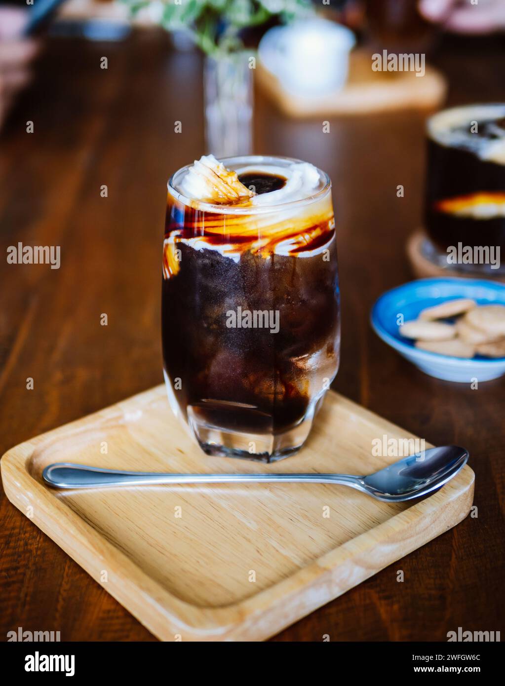 Coconut américain glacé. Un verre clair de couche glacé americano avec de l'eau de coco fraîche jeune et de la viande de coco sur la table, une boisson fraîche d'été et la maison b Banque D'Images