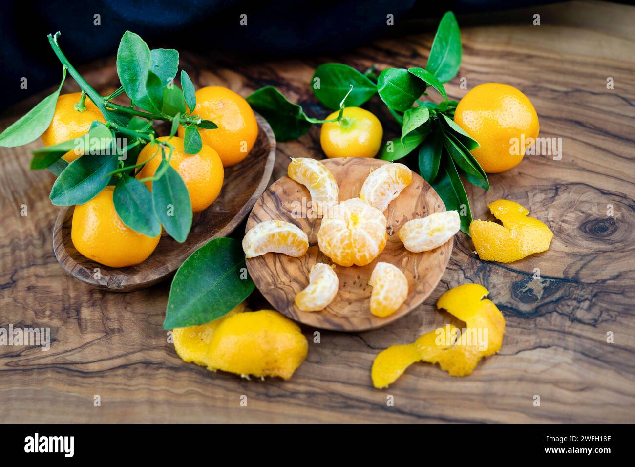 Calamondin, Calomondin, Camalmansi (Citrus madurensis, Citrofortunella microcarpa, Citrus fortunella, citrus mitis), fruits sur la table, partiellement pelés Banque D'Images