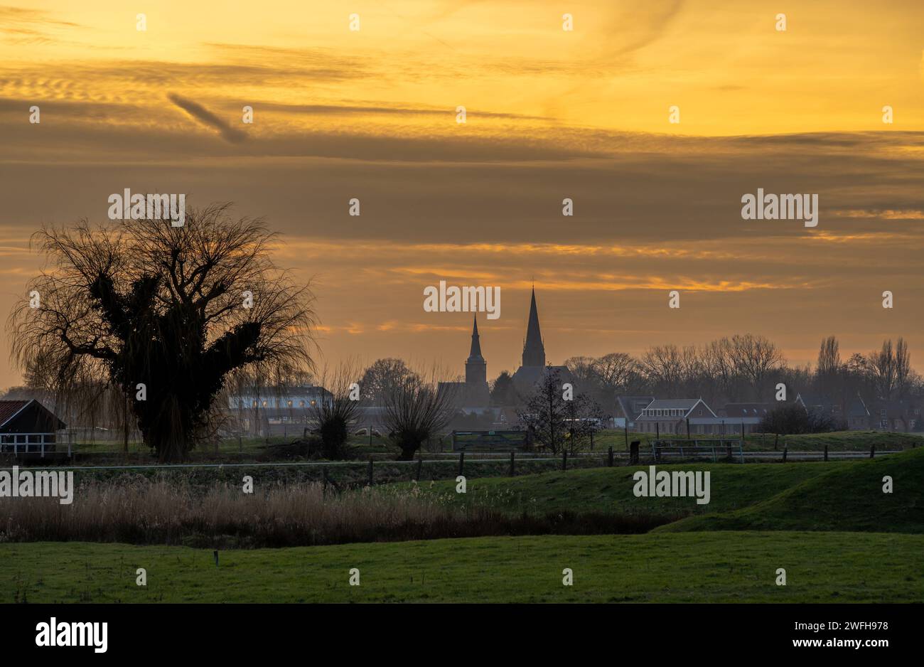 Campagne hollandaise au coucher du soleil, vue sur les tours de l'église et les terres agricoles d'Abcoude Banque D'Images