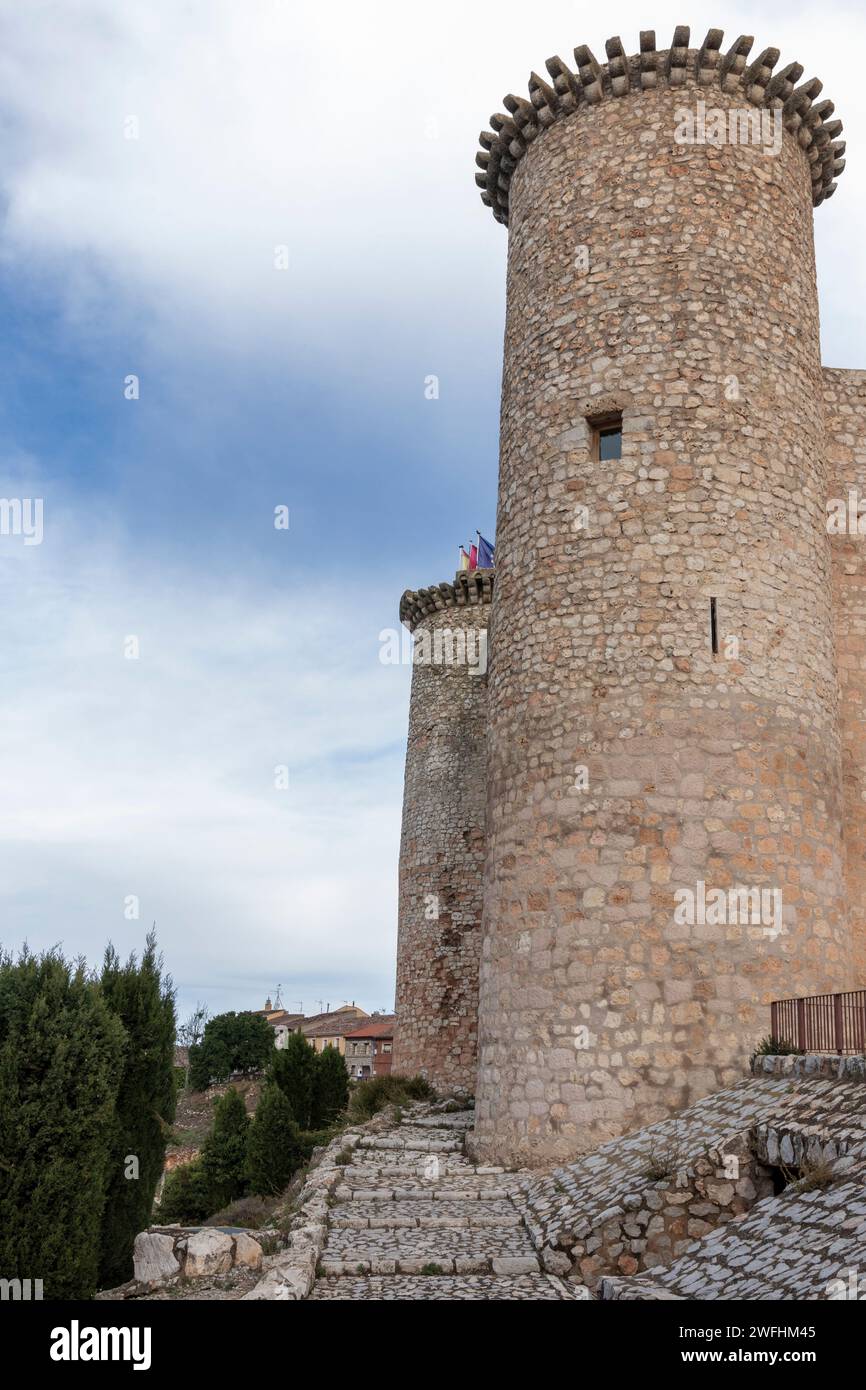 château historique en pierre avec une tour ronde, sous un ciel nuageux, avec des gens visibles au sommet, entouré de verdure. Banque D'Images