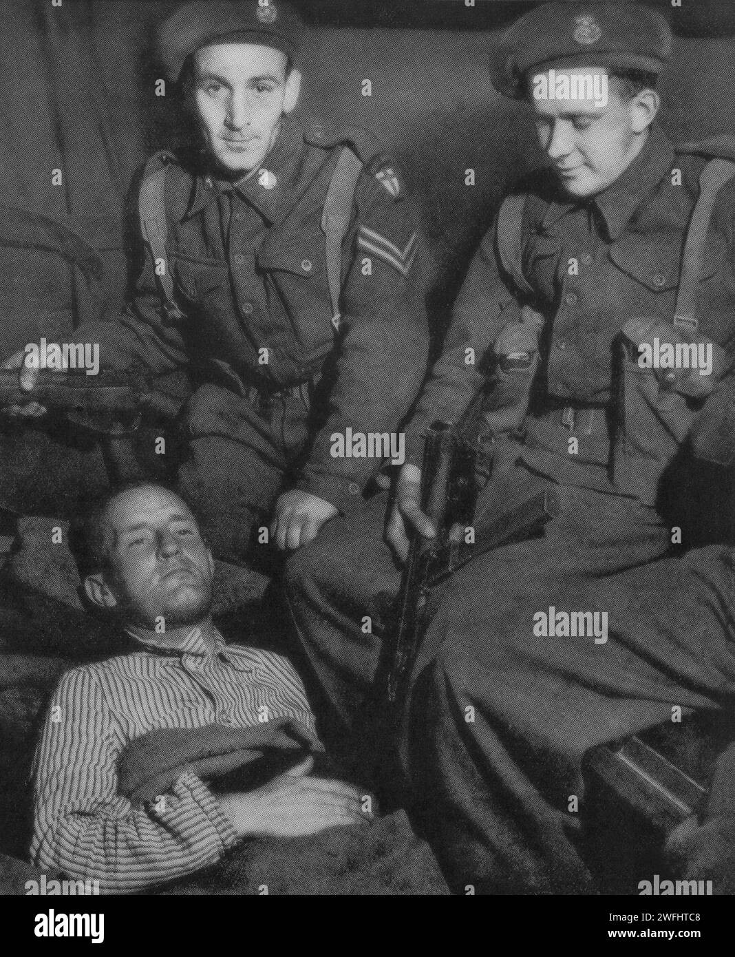 William Joyce alias Lord Haw-Haw sous garde après sa capture le 29 mai 1945, par les troupes de la deuxième armée à la frontière danoise-allemande. Il était un diffuseur de propagande fasciste et nazi né aux États-Unis pendant la Seconde Guerre mondiale. Il a ensuite été reconnu coupable de haute trahison au Royaume-Uni, condamné à mort et pendu à la prison de Wandsworth. Banque D'Images