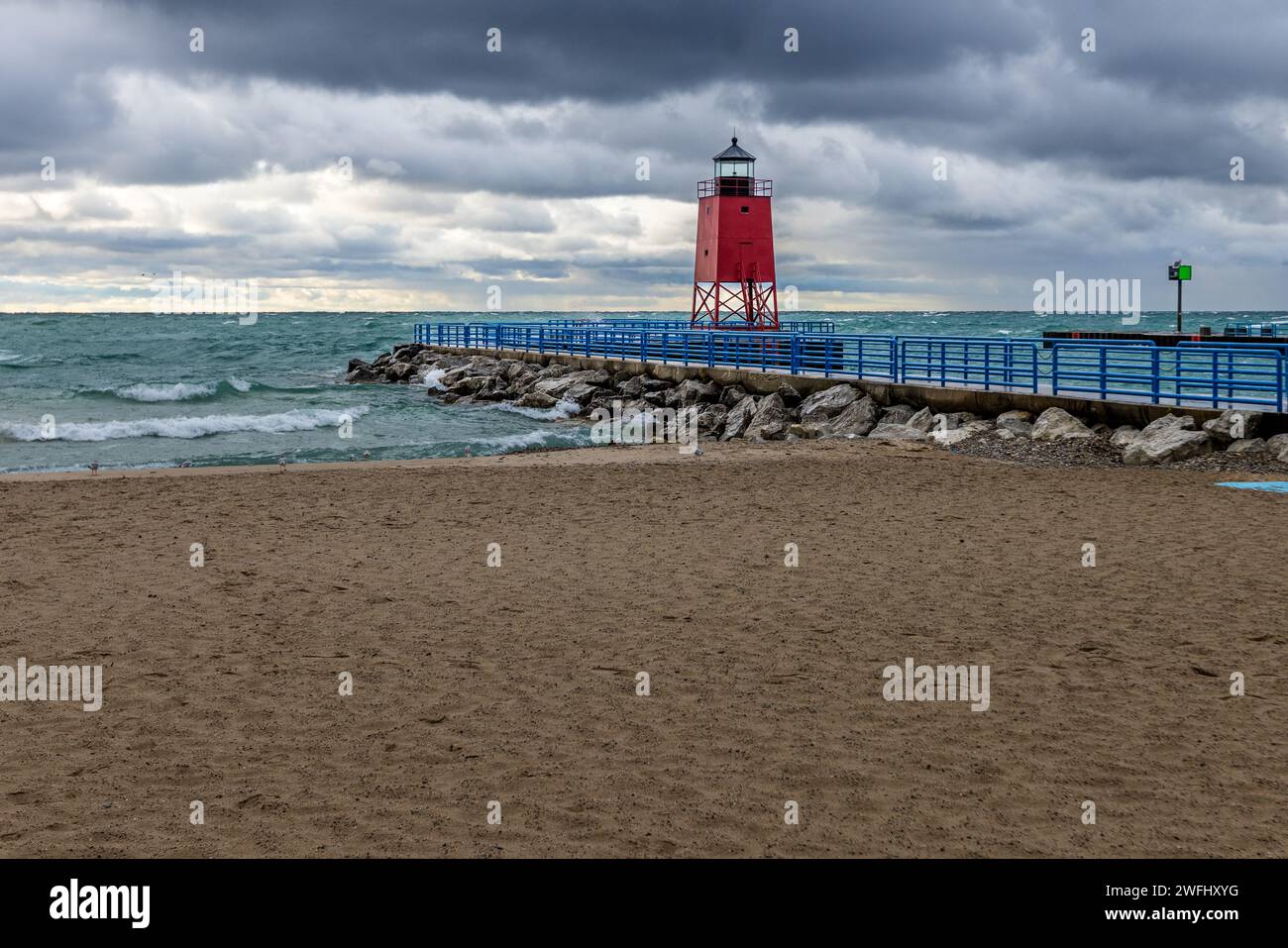 Journée orageuse sur la plage de Charlevoix avec le phare du quai Sud de Charlevoix en arrière-plan. Charlevoix, Michigan, États-Unis Banque D'Images