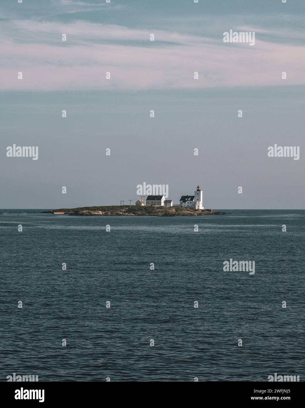 Phare se dresse au sommet de l'île isolée dans le vaste océan Banque D'Images