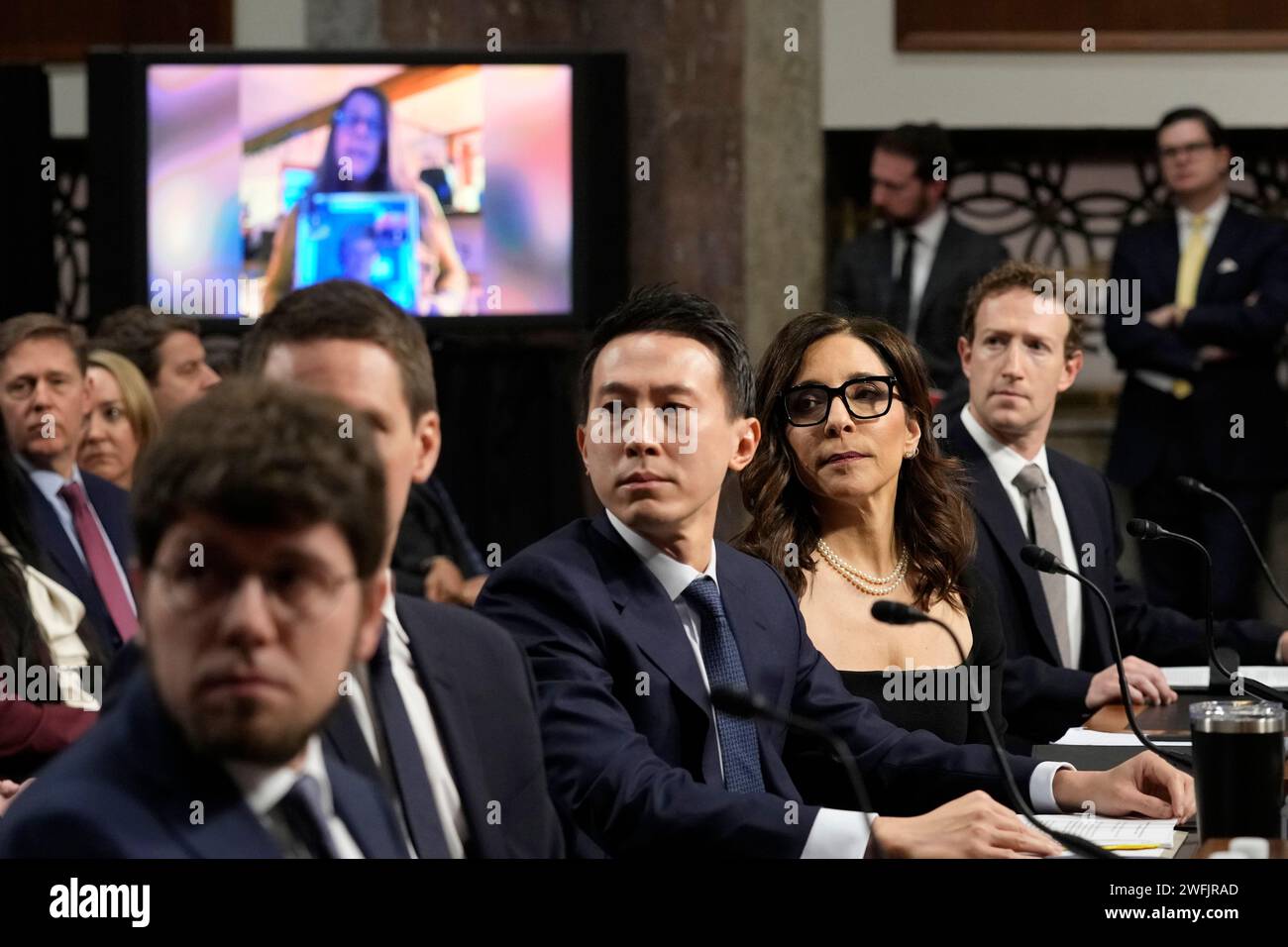 Social media platform heads, from left, Discord CEO Jason Citron, Snap CEO Evan Spiegel, partially hidden, TikTok CEO Shou Zi Chew, X CEO Linda Yaccarino, and Meta CEO Mark Zuckerberg, watch a video during a Senate Judiciary Committee hearing on Capitol Hill in Washington, Wednesday, Jan. 31, 2024, to discuss child safety. (AP Photo/Susan Walsh) Banque D'Images