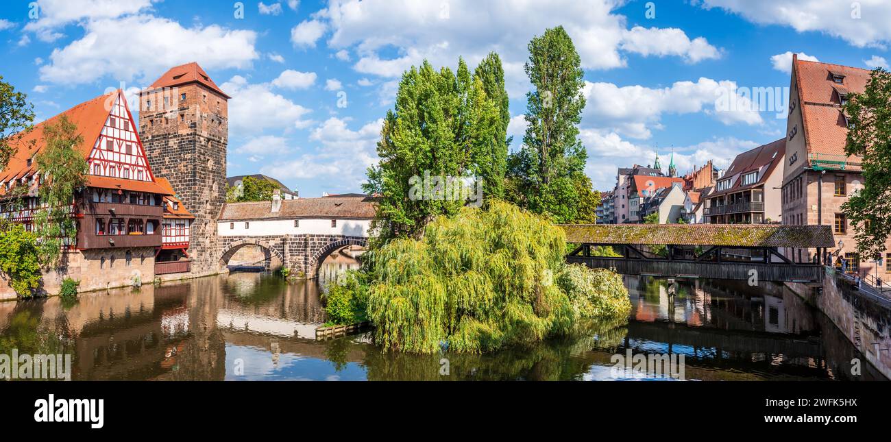 Le Henkersteg et le Henkerbrücke sur la rivière Pegnitz à Nuremberg, en Allemagne, avec la maison à colombages Weinstadel et la tour en pierre Wasserturm. Banque D'Images