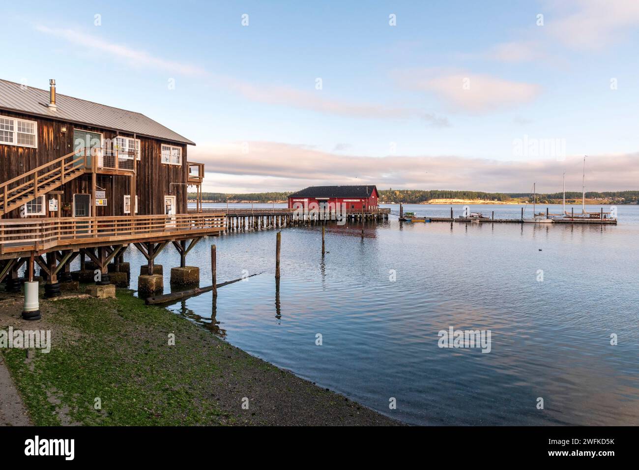 Le quai historique rouge de Coupeville s'avance dans Penn Cove depuis Front Street dans le quartier historique de cette petite ville de Whidbey Island, Washington Banque D'Images