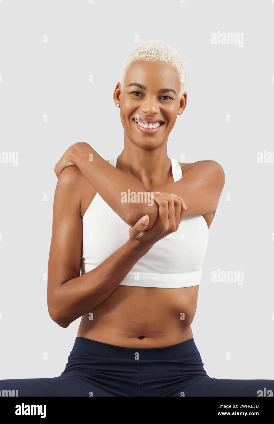 Entraînement de fitness, femme souriante étirant les bras, athlète féminine africaine latino-américaine en vêtements de sport, Sportswoman font de l'exercice physique d'entraînement dans la salle de gym Banque D'Images