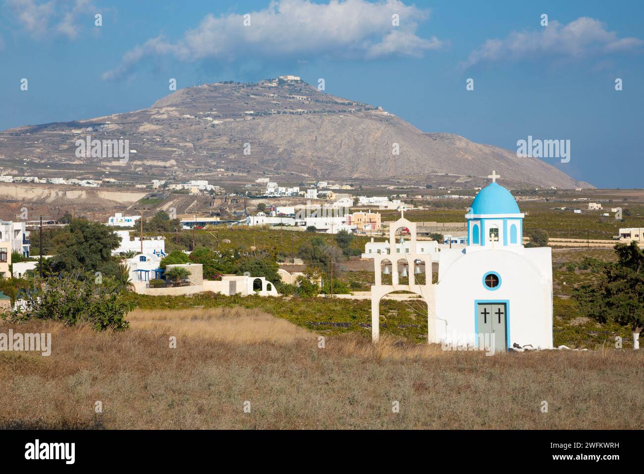 Santorin - La petite chapelle sur Akrotiri et mont Profitis Ilias dans le contexte. Banque D'Images