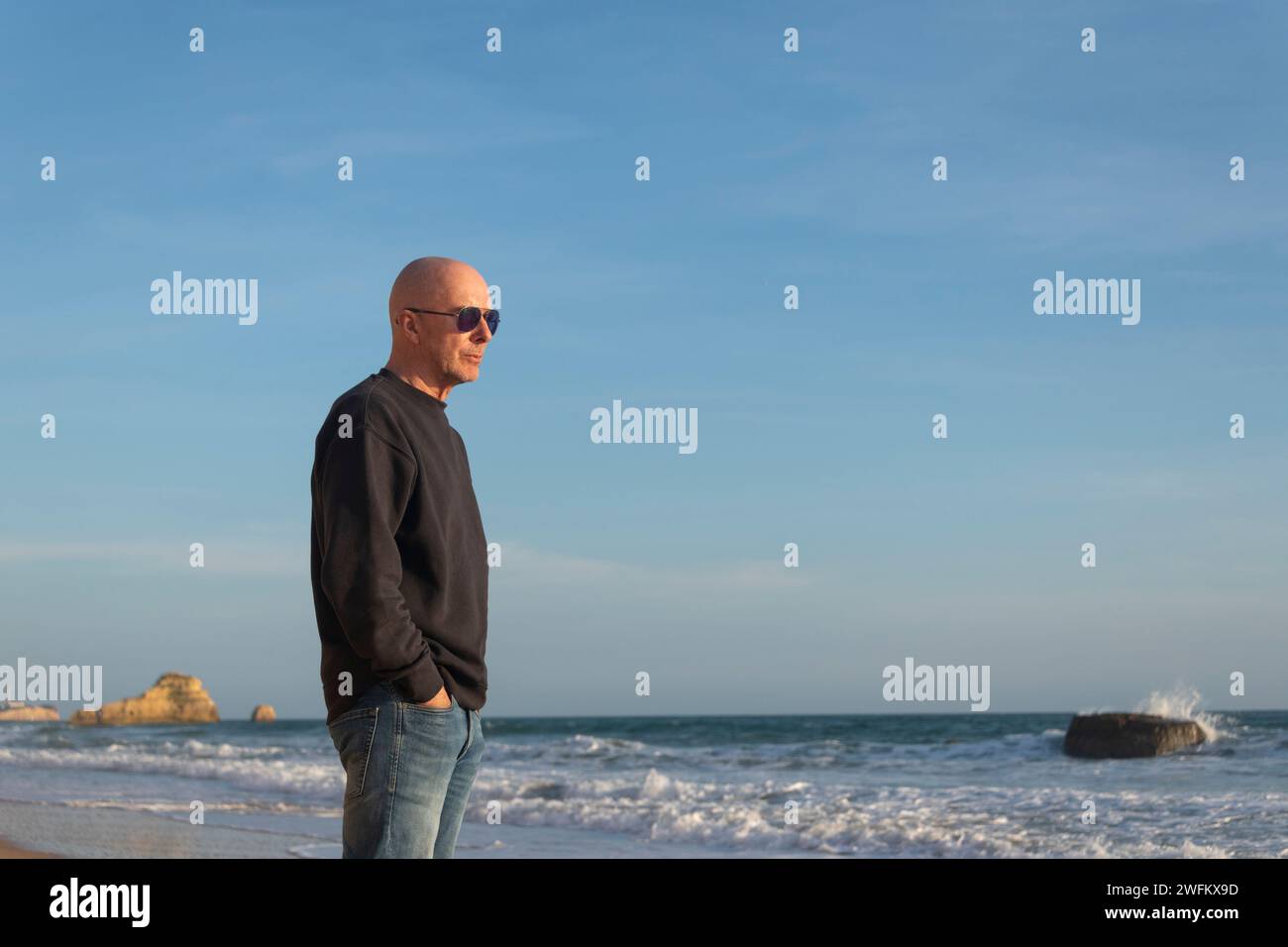 homme mûr debout regardant la mer et les vagues Banque D'Images homme mûr debout regardant la mer et les vagues Banque D'Images