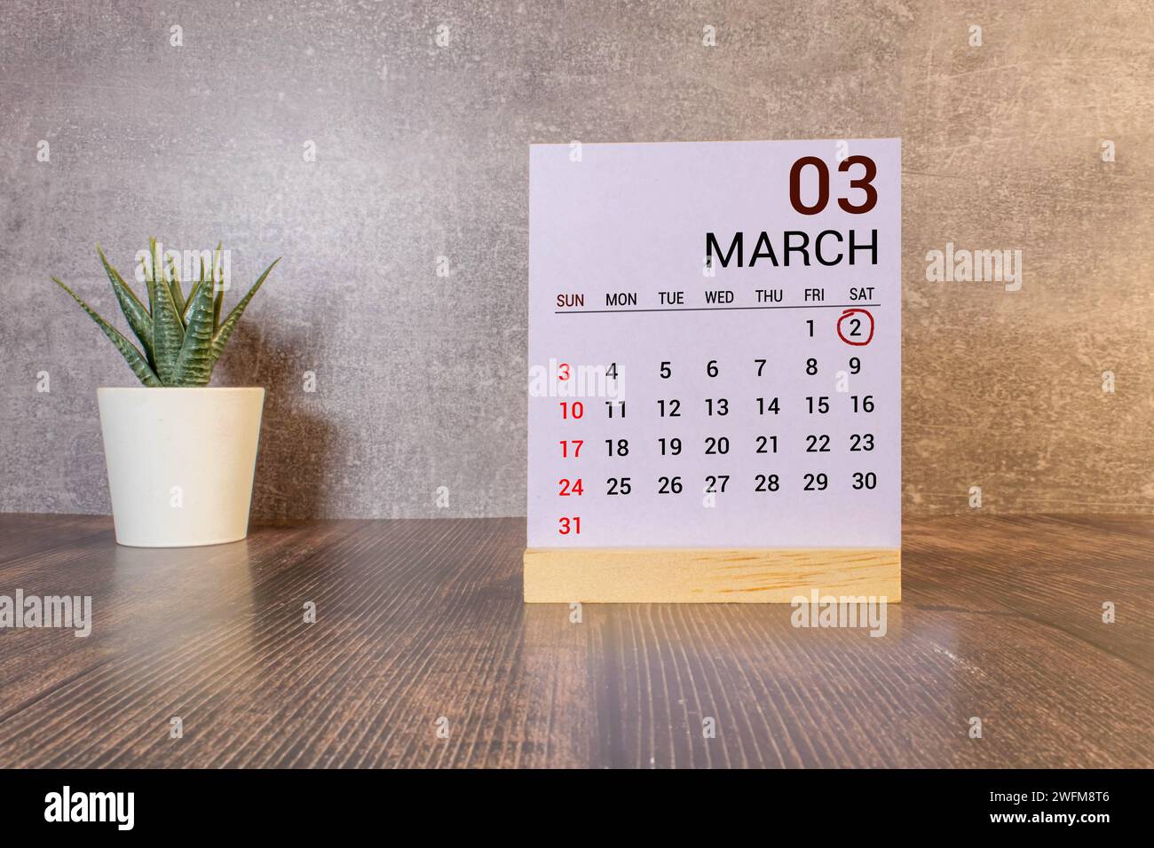 Mars 02 texte de la date du calendrier sur bloc de bois blanc avec des stationeries sur le bureau en bois. Concept de date de calendrier. Banque D'Images
