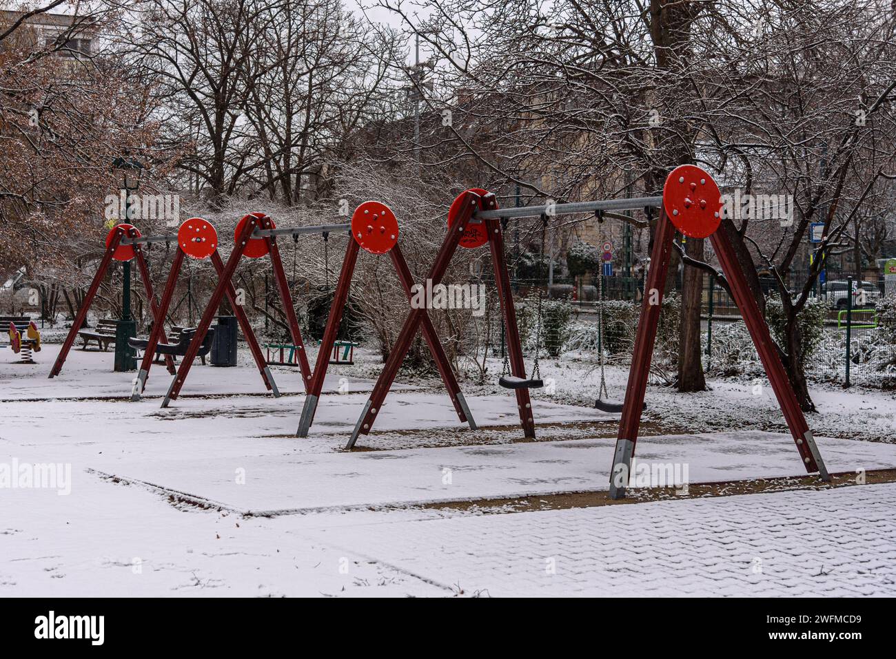 Balançoire dans la neige sur une aire de jeux en hiver Banque D'Images