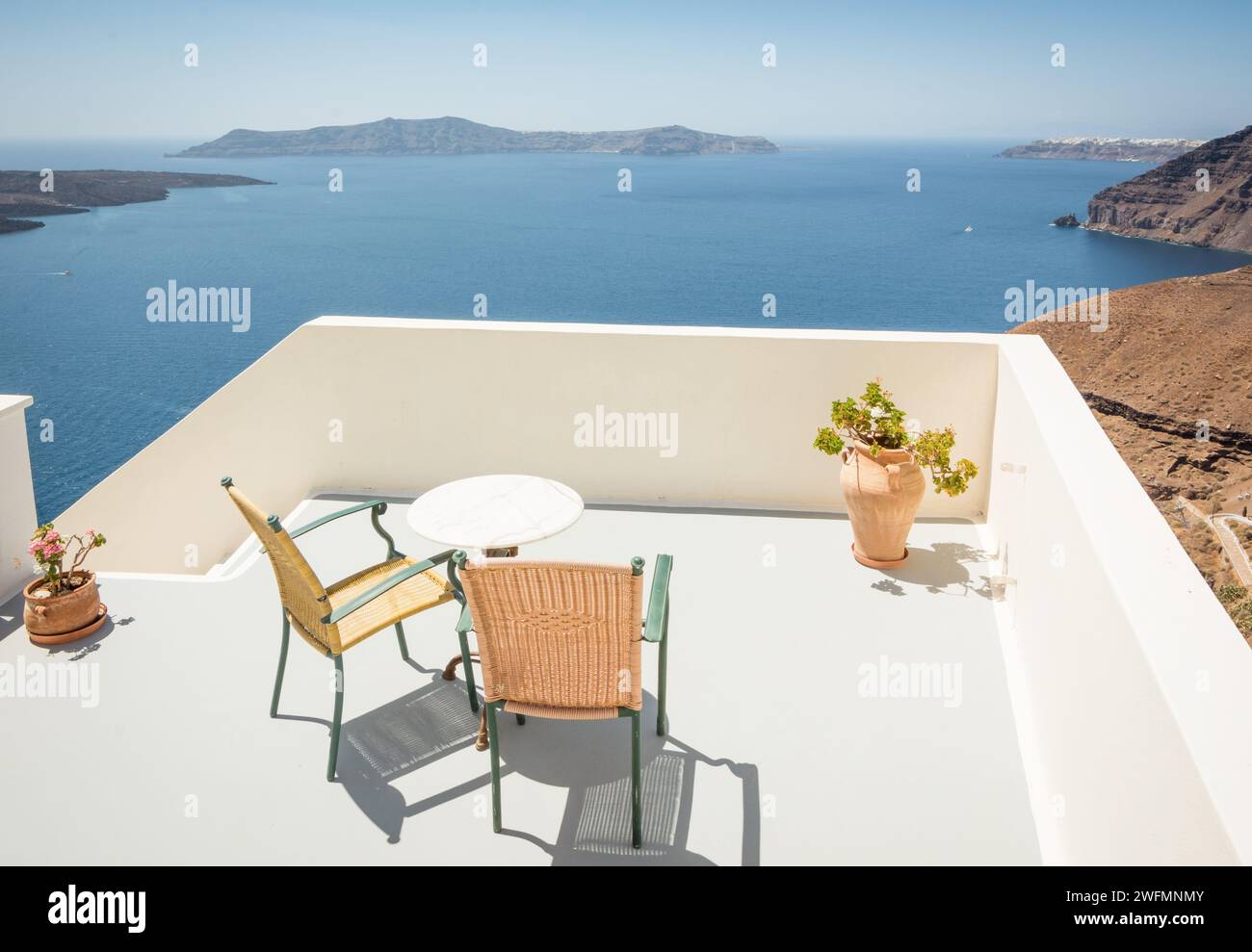 Avec deux chaises sur la falaise de l'île de Santorin. Table de café avec vue depuis le village de Thera aux îles des Cyclades. Banque D'Images
