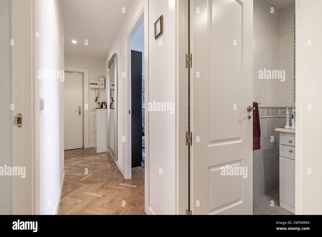 Couloir d'une maison résidentielle avec portes en bois laqué blanc et parquet en chêne français Banque D'Images