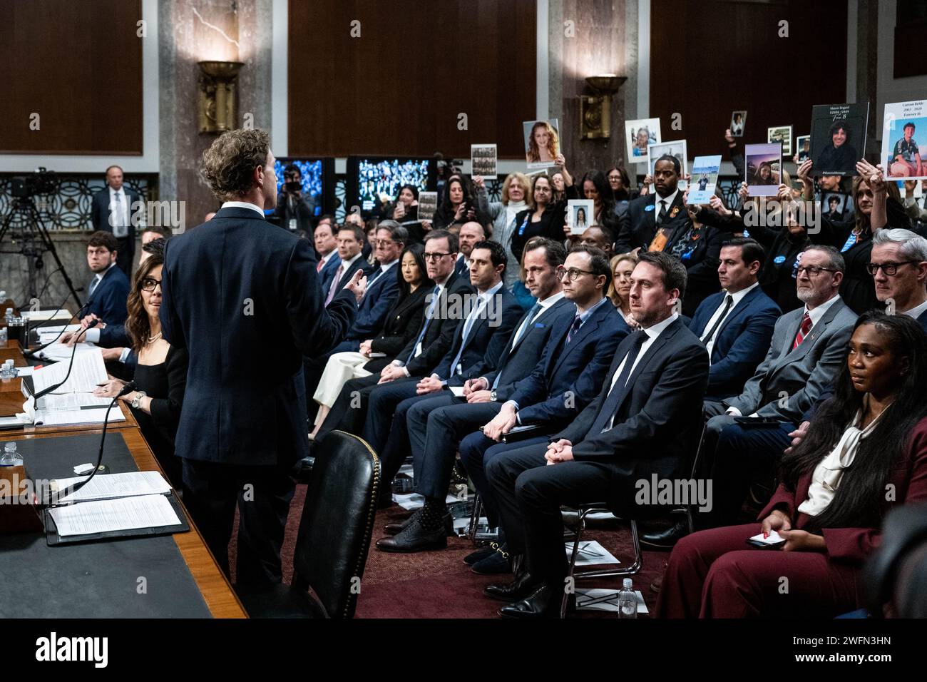 Washington, États-Unis. 31 janvier 2024. Mark Zuckerberg, fondateur et président-directeur général de Meta, s'entretenant avec des activistes tenant des photos d'enfants blessés par les médias sociaux lors d'une audience du comité judiciaire du Sénat au Capitole des États-Unis. Crédit : SOPA Images Limited/Alamy Live News Banque D'Images