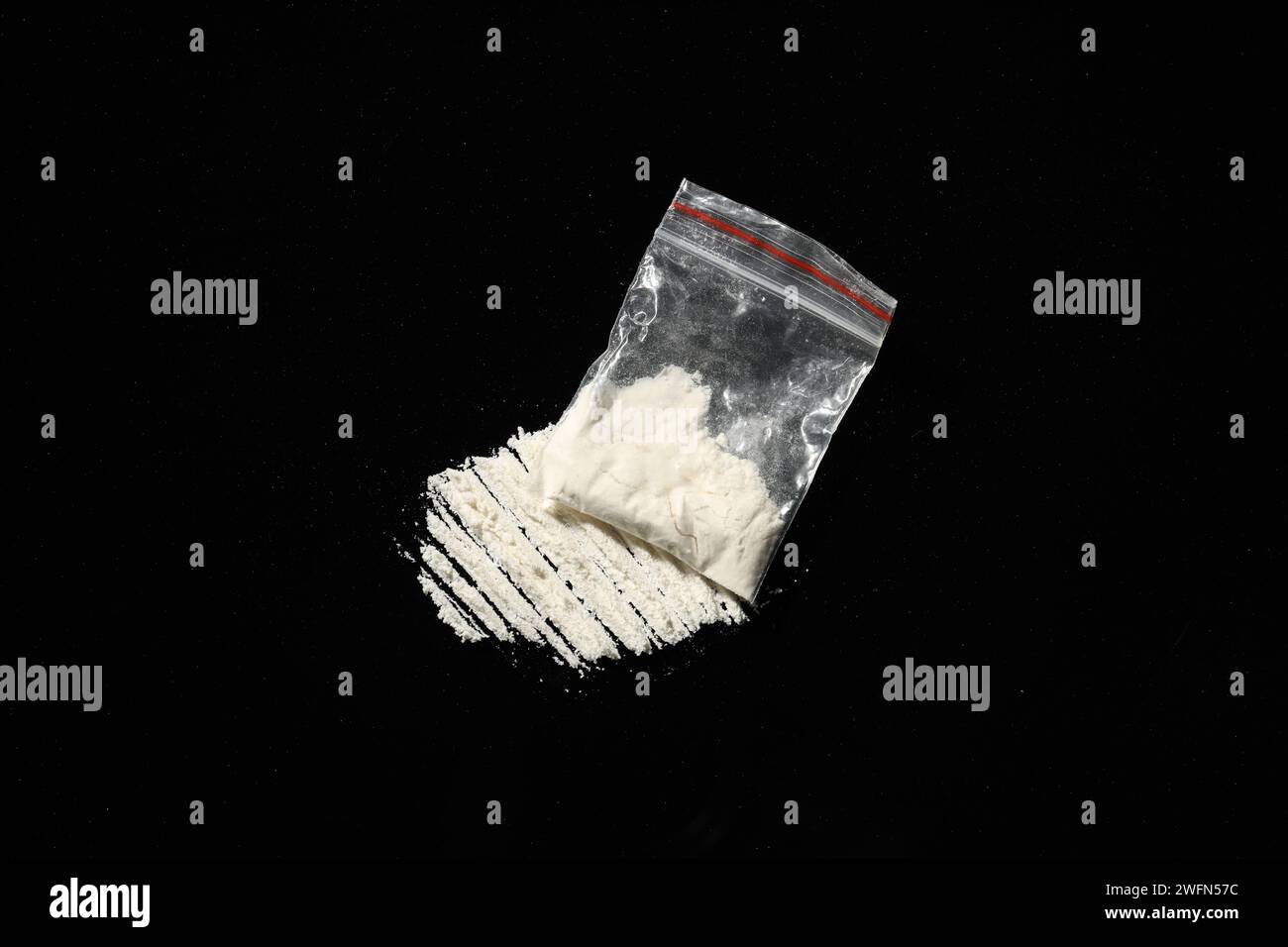 Toxicomanie. Sac en plastique avec cocaïne sur fond noir, vue au-dessus Banque D'Images