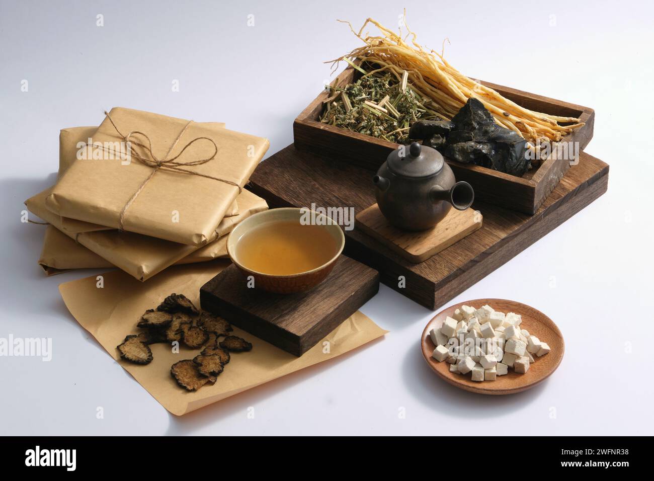 Un plat de Poria cocos, Szechuan Lovage Rhizome, un bol de médecine et un pot en terre mis sur un podium, exposé avec un plateau de quelques herbes. Herbal medici Banque D'Images