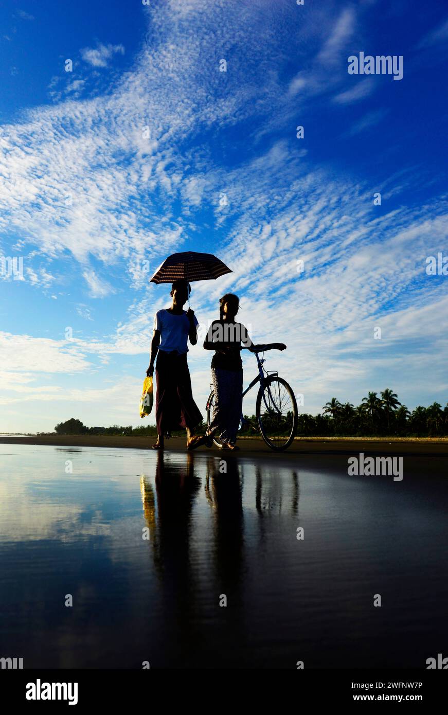 Femmes arakanaises marchant sur la plage de Sittwe, État de Rakhine, Myanmar. Banque D'Images