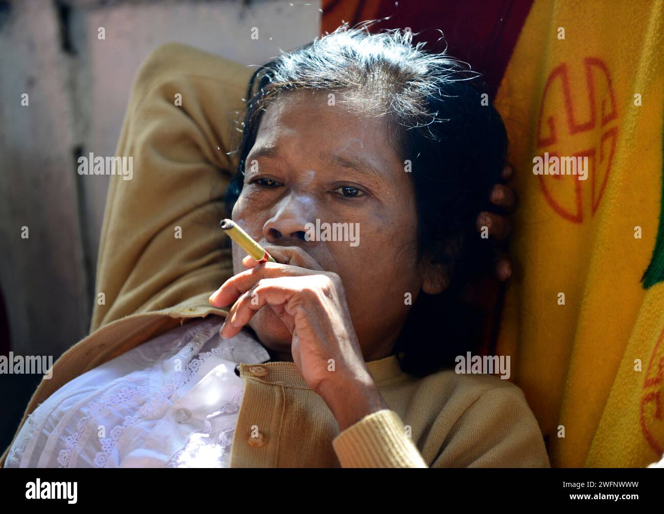 Une femme Arakanaise fumant un chéroot sur un bateau entre Sittwe et Mrauk-U dans l'État de Rakhine, Myanmar. Banque D'Images