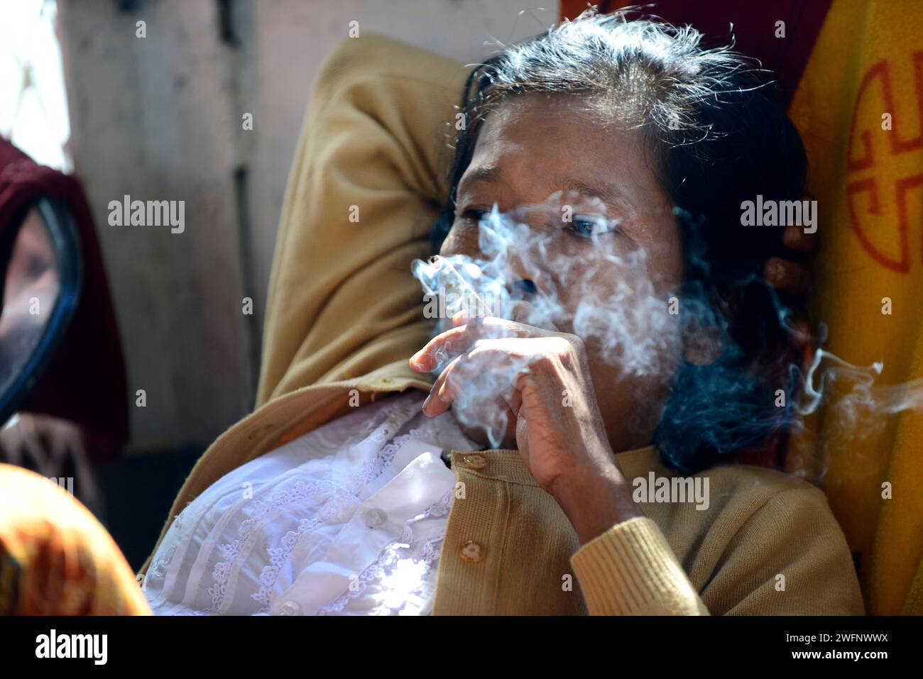Une femme Arakanaise fumant un chéroot sur un bateau entre Sittwe et Mrauk-U dans l'État de Rakhine, Myanmar. Banque D'Images