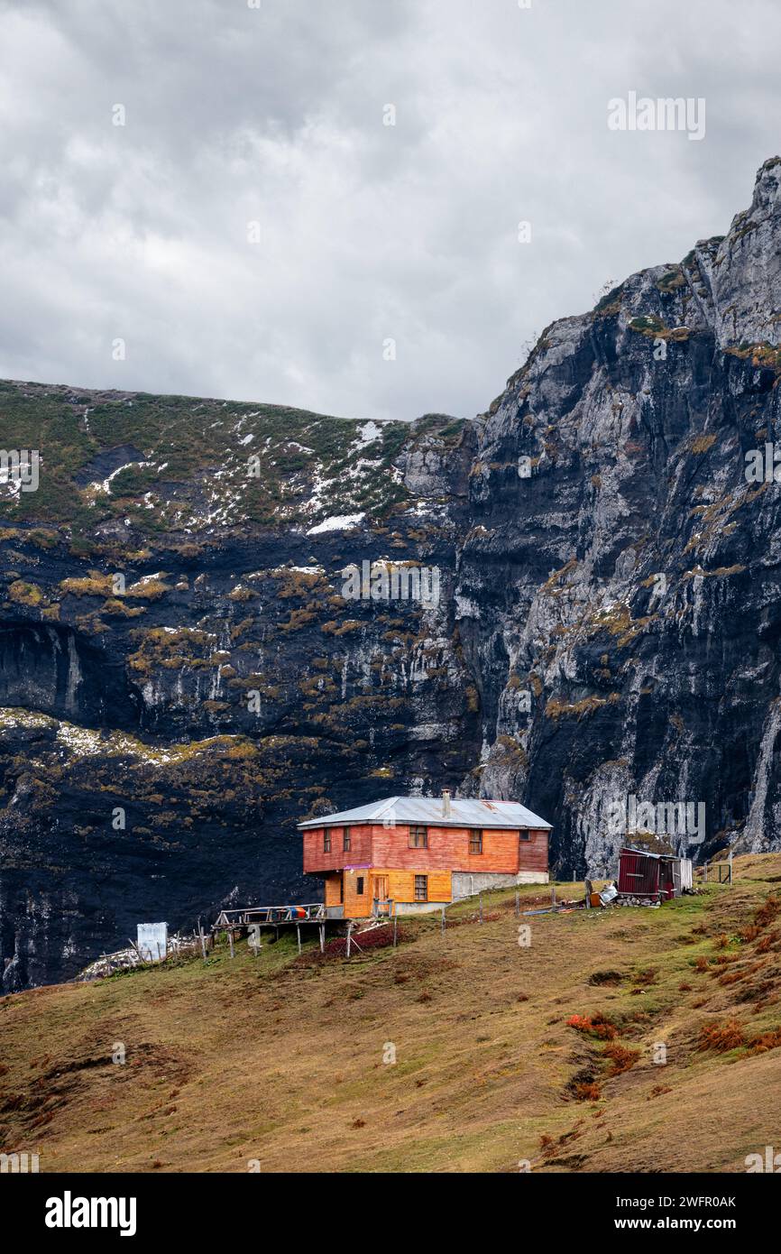 Maisons de plateau au sommet de la montagne. Roches noires et ciel en arrière-plan. Cabanes dans la verdure. Banque D'Images