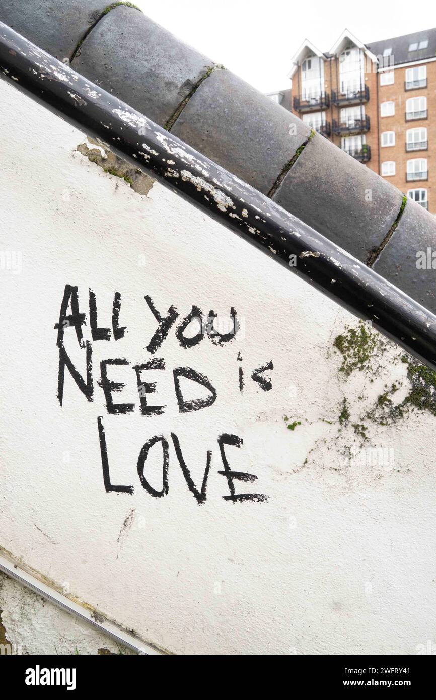 Londres, Royaume-Uni. Un graffiti à Londres récitant « All You Need is Love » sur un mur de pont avec un immeuble résidentiel en arrière-plan. Cristina Banque D'Images