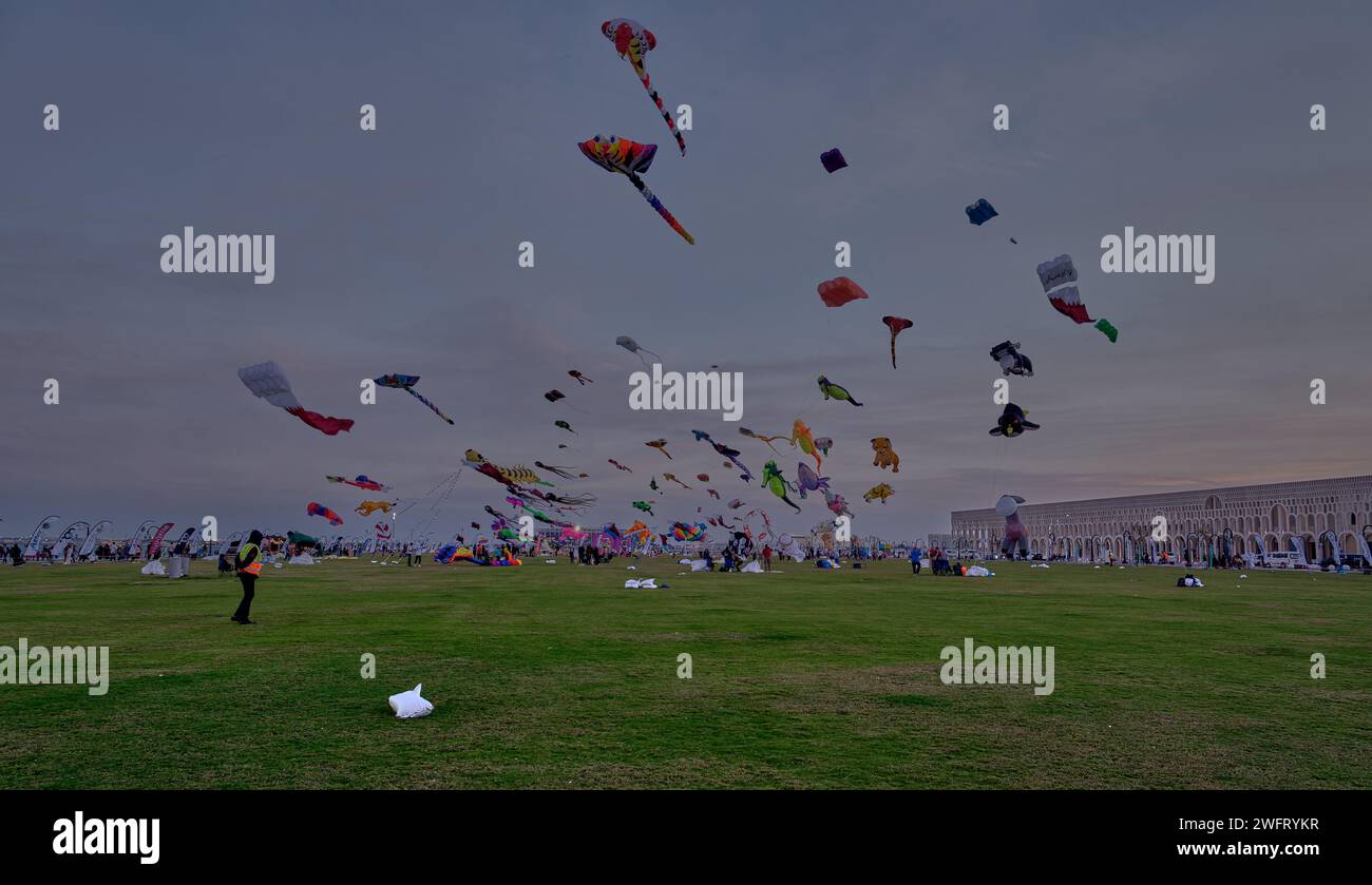 Qatar Kite Festival 2024 dans le vieux port de Doha (district de Mina) coucher du soleil montrant une vitrine spectaculaire de cerfs-volants colorés planant à travers Doha, Skyline Banque D'Images